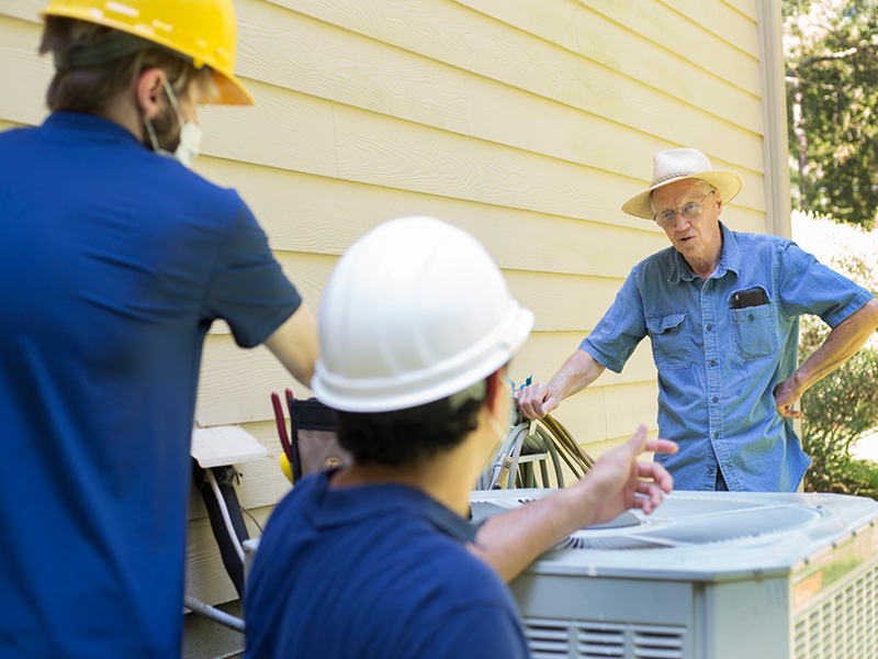 Technician talking with person in front of unit for efficient and prompt repair service in Goodlettsville, TN